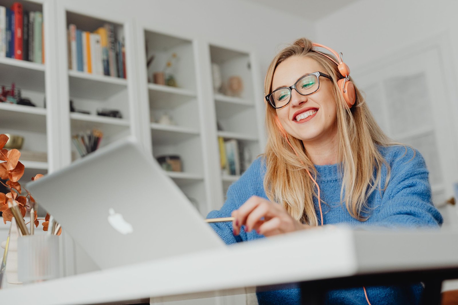 A woman smiling during an online session with headphones