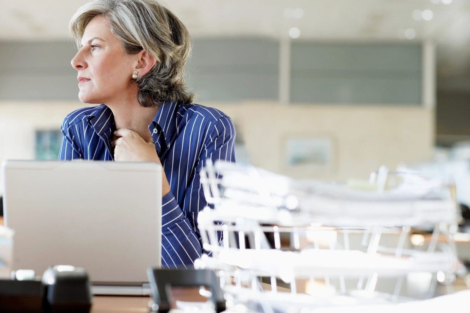 A woman sitting at a table with her laptop.