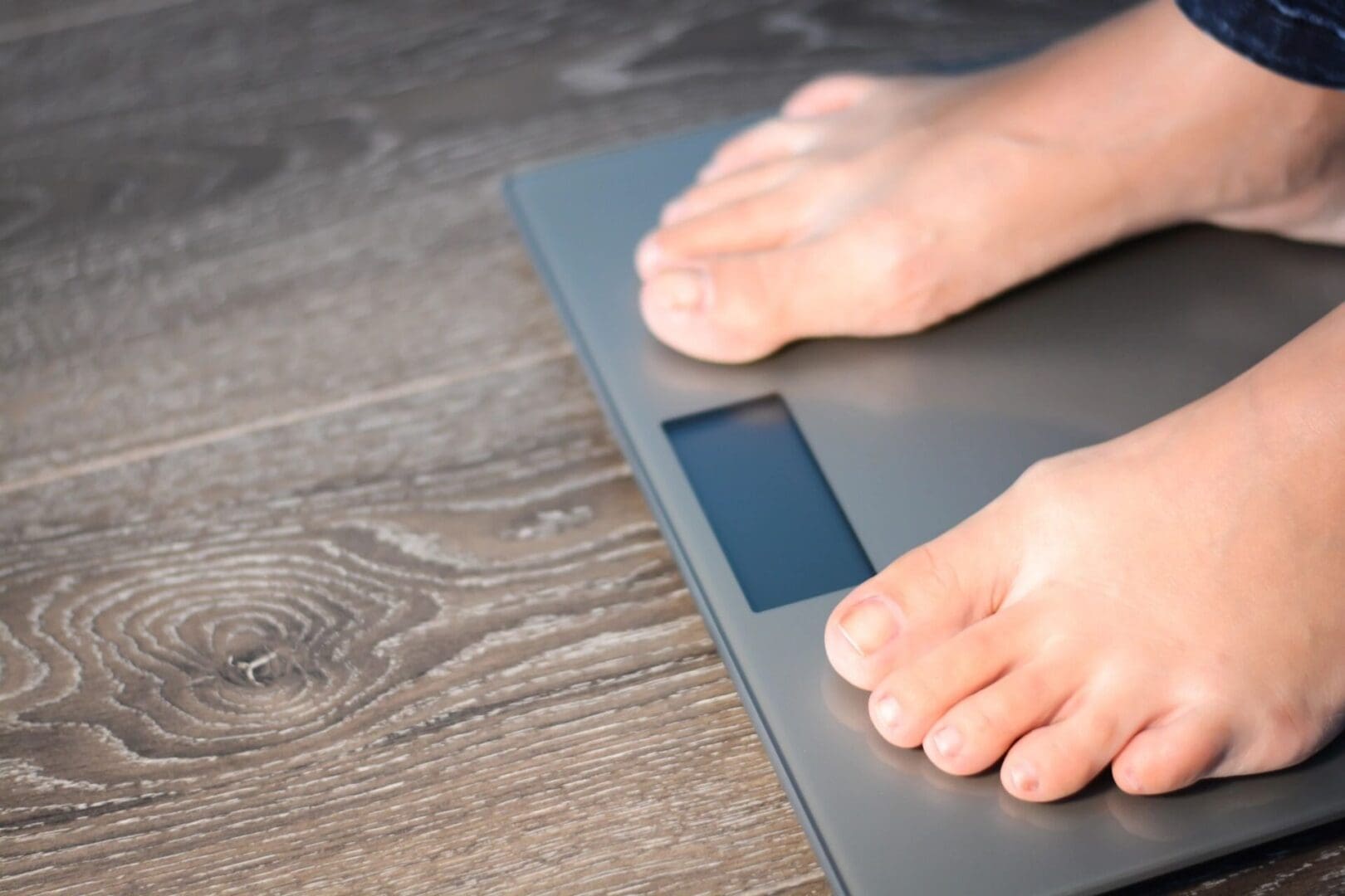 A person standing on a scale with their feet on the floor.