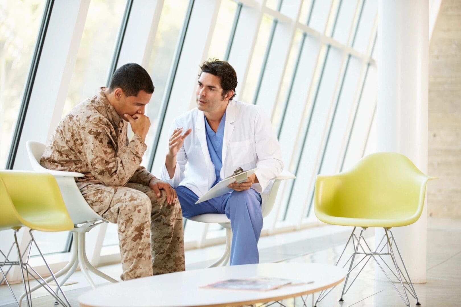 A doctor and soldier are sitting in front of each other.